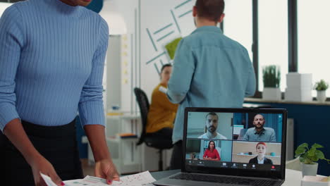 African-american-woman-using-laptop-in-online-meeting-with-clients-and-manager-talking-about-marketing-strategy