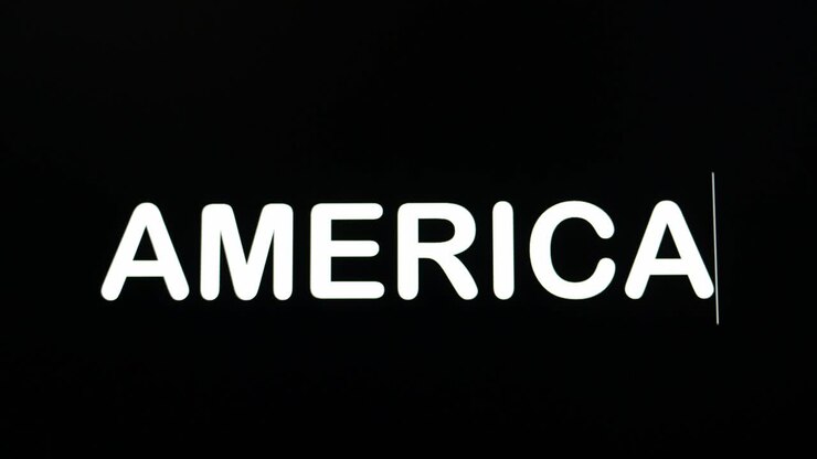 Close up of AMERICA being typed into computer monitor screen with blinking cursor on black background copy space