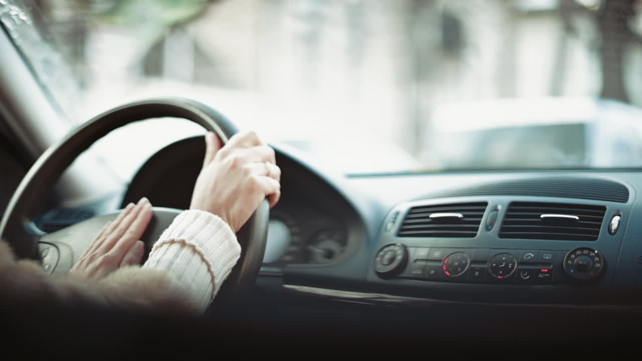 Woman driving a car in slow motion, hands on wheel