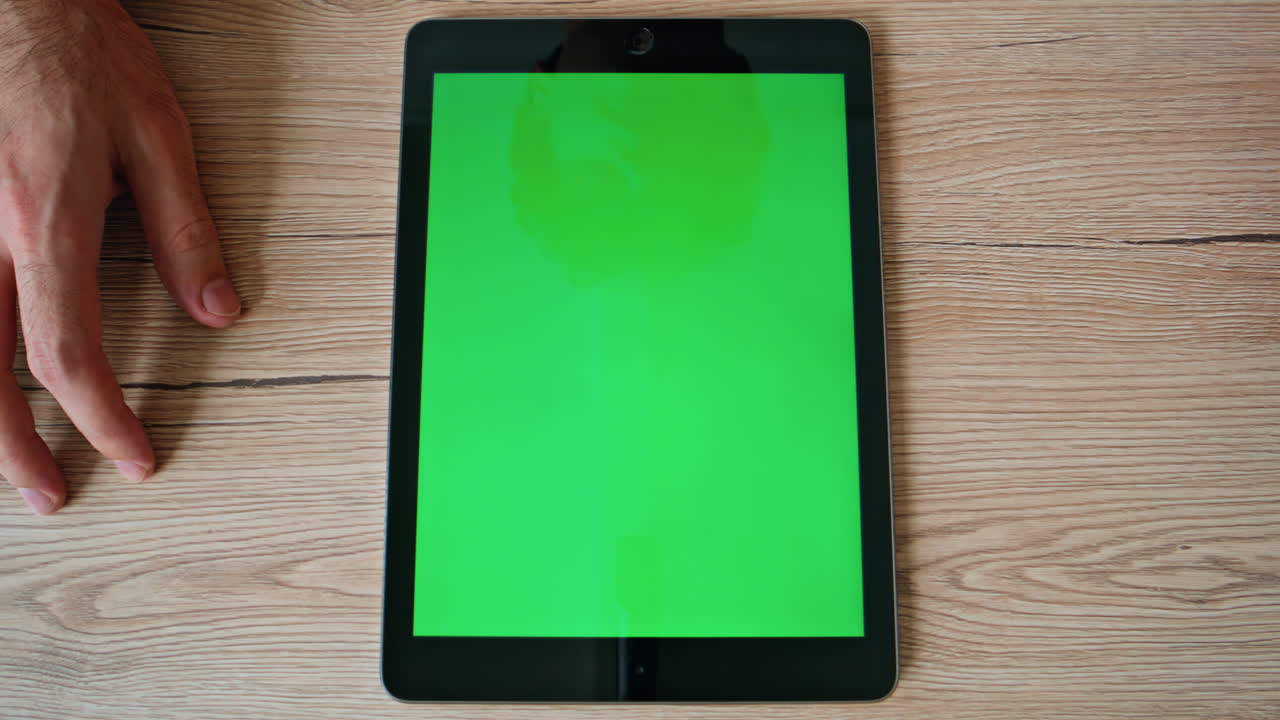 Student tapping greenscreen tablet browsing webinar at home table closeup top
