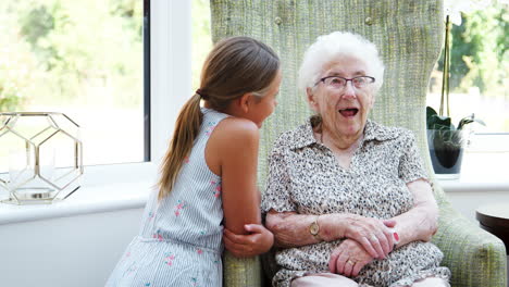 granddaughter sitting and talking with grandmother during visit to retirement home