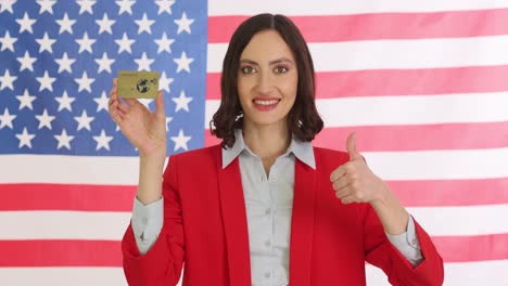 woman holding a credit card in front of an american flag