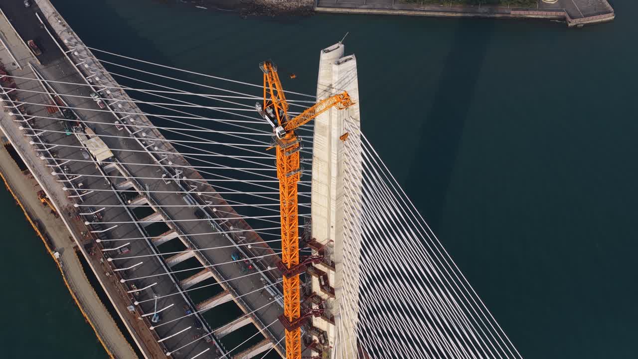 Aerial view of a cable stayed bridge construction crane lifting infrastructure