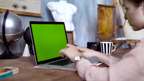 mujer trabajando en una computadora portátil en el estudio de un artista