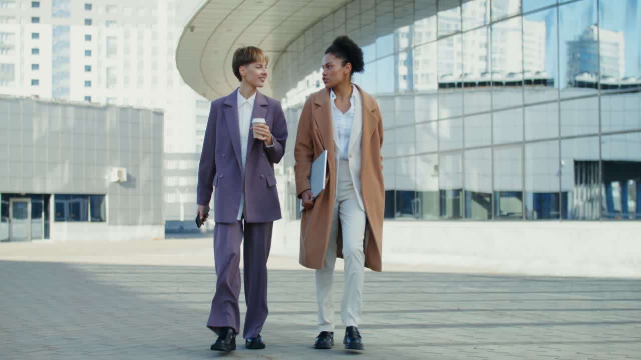 dos mujeres de negocios caminando y hablando