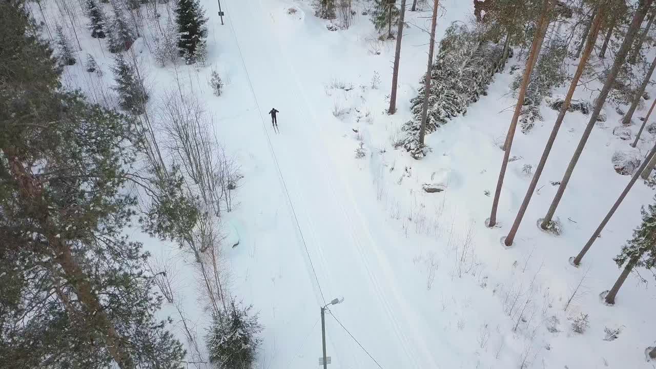 Fondista ripreso dall'alto, ripresa con drone in discesa.