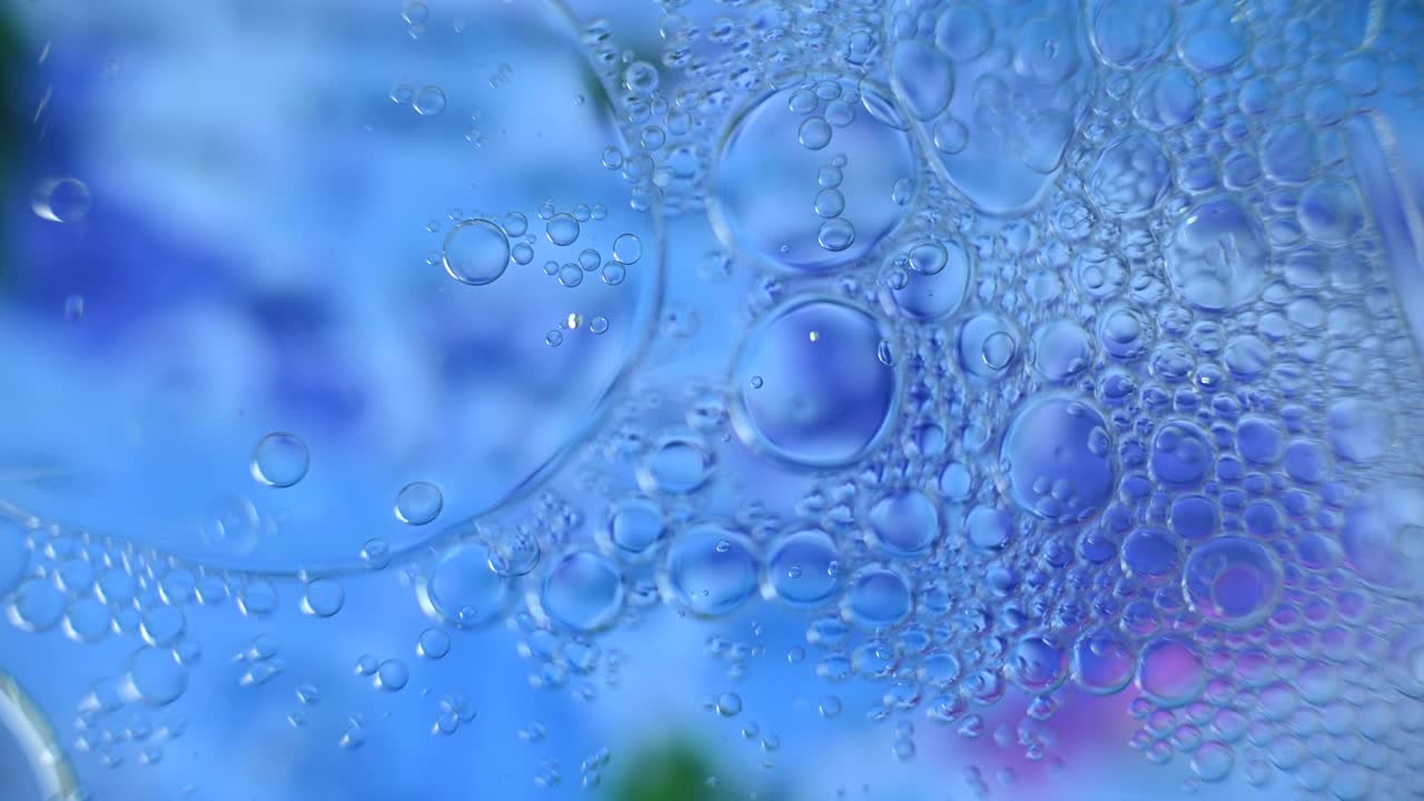 추상적인 기름은 다채로운 물에 떨어집니다.