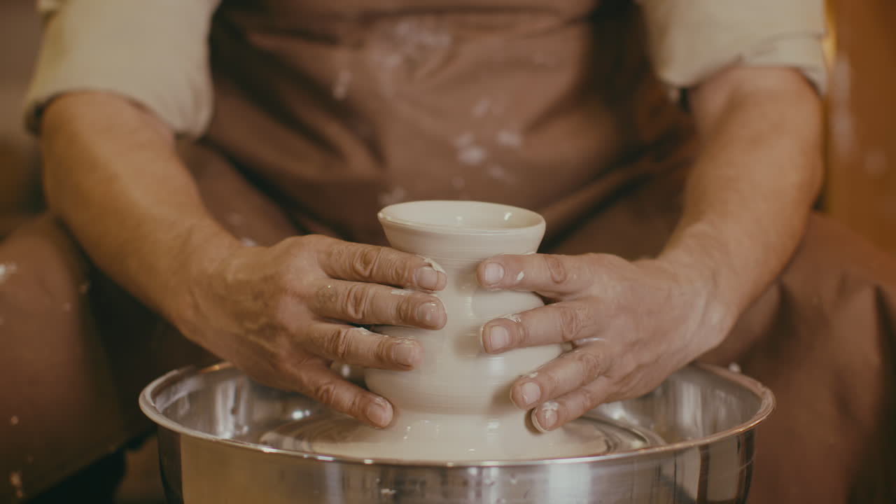 Pottery Artist Shaping a Clay Vessel on a Potters Wheel