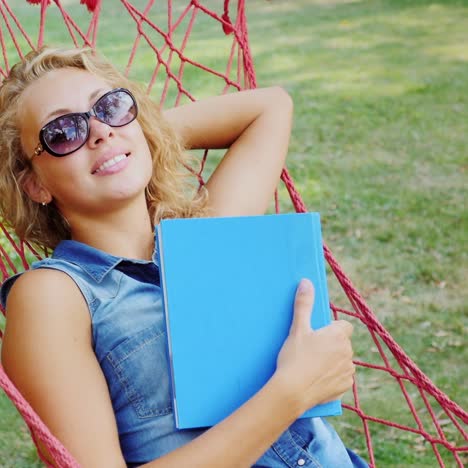 Attractive-woman-rests-in-a-hammock-on-a-summer-day-3