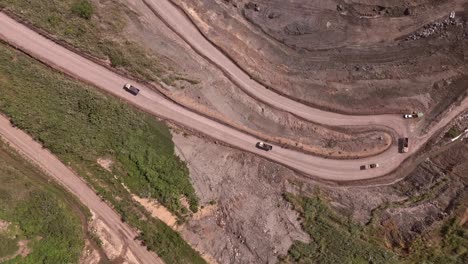 Overhead-Drone-View-of-Trucks-Hauling-Dirt-Away-From-Siana-Glod-and-Silver-mine,-Mainit,-Philippines