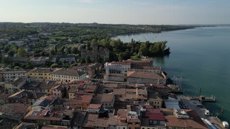 aerial shot of italian villa with stone homes and castle on the water