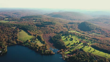 Hermoso-Dron-Disparó-Sobre-El-Paisaje-Rural-Con-El-Lago-Azul-Rodeado-De-Terreno-Montañoso-Cubierto-Por-Una-Densa-Vegetación-Verde-En-El-Condado-De-Litchfield,-Connecticut,-Estados-Unidos