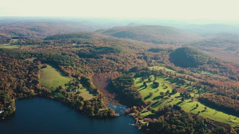 hermoso dron disparó sobre el paisaje rural con el lago azul rodeado de terreno montañoso cubierto por una densa vegetación verde en el condado de litchfield, connecticut, estados unidos