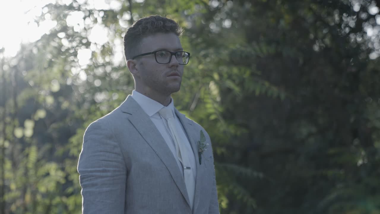 Groom adjusts his tie and watch then looks at camera with sun in the background. 4k60 fps. Email willneatheryyahoo.com to purchase entire wedding event at cheap wholesale price.