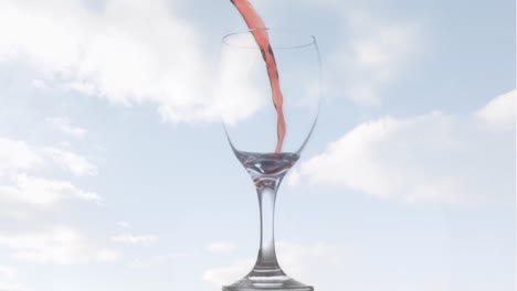 Animation-of-rose-wine-pouring-into-glass-on-background-with-clouds