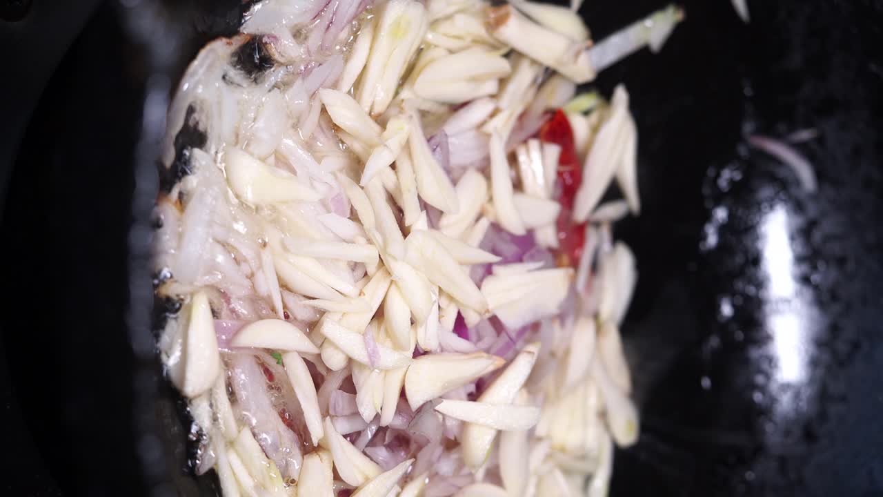 Cooking onions, garlic and chilies in a pan