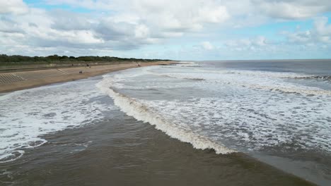 Englischer-Badeort,-Aufgenommen-Mit-Einer-Drohne,-Die-Einen-Hohen-Aussichtspunkt-Aus-Der-Luft-Zeigt,-Der-Einen-Weiten-Sandstrand-Mit-Einem-Pier-Und-Tosenden-Wellen-Zeigt-2