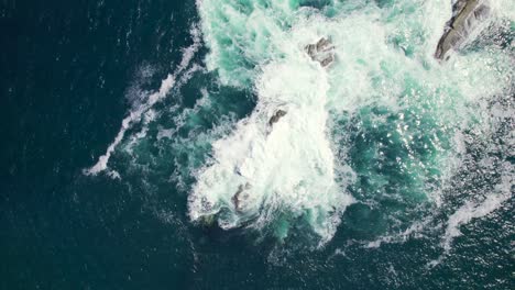 Vista-Aérea-De-Una-Roca-Marina-Con-Salpicaduras-De-Agua