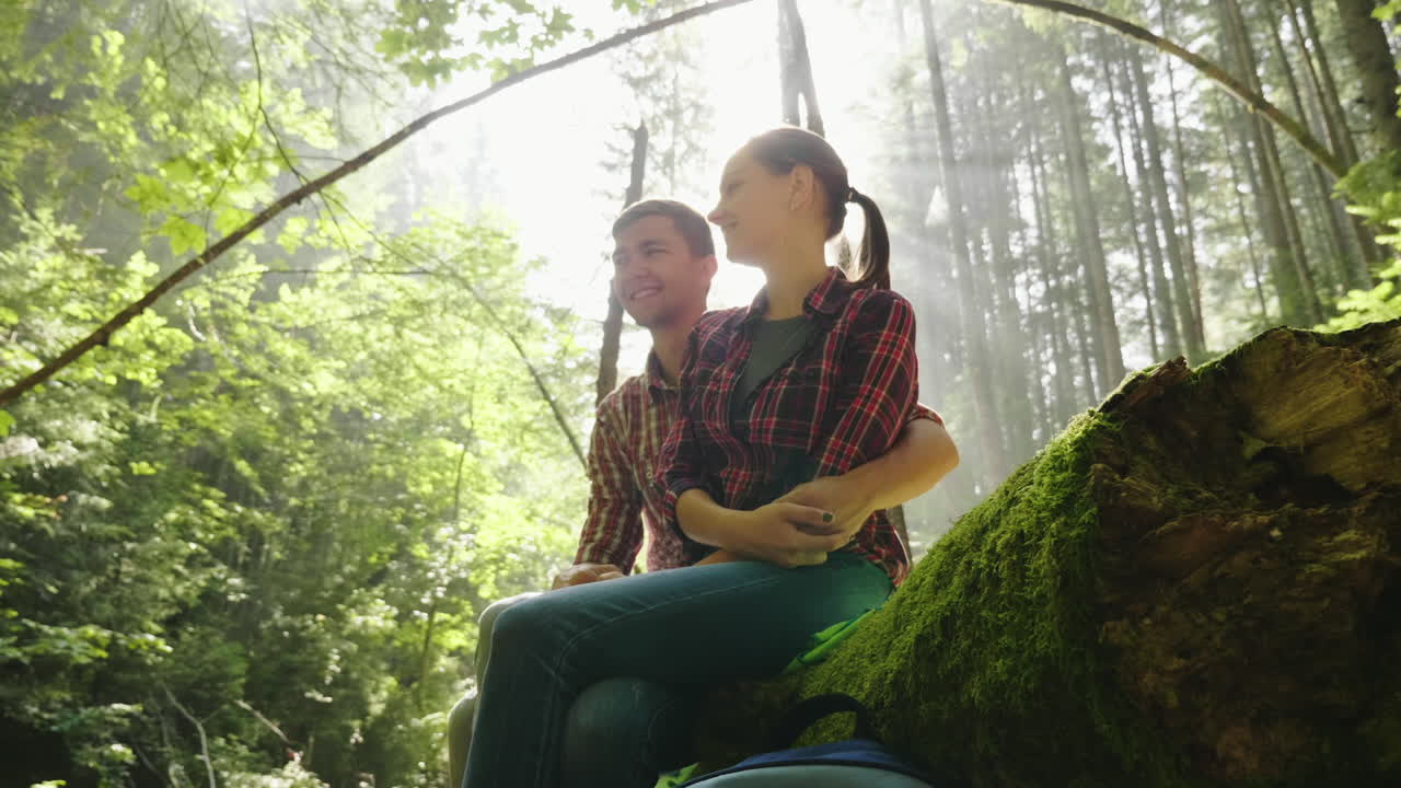 una pareja joven camina por un sendero panorámico en el bosque