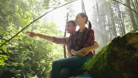 a young couple walks along a scenic path in the woods