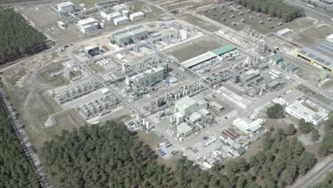 high drone shot providing wide overview of large industrial factory zone, including solar panels and forest, castets, france
