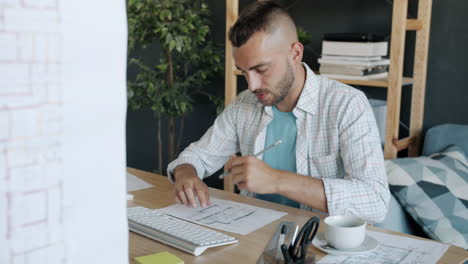focused designer working on plans at home office