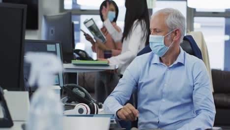 retrato de un hombre con una máscara facial sentado en su escritorio en la oficina