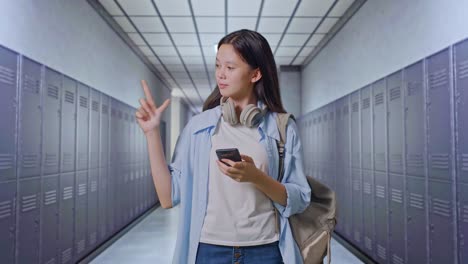 una adolescente usando un teléfono inteligente en el pasillo de la escuela