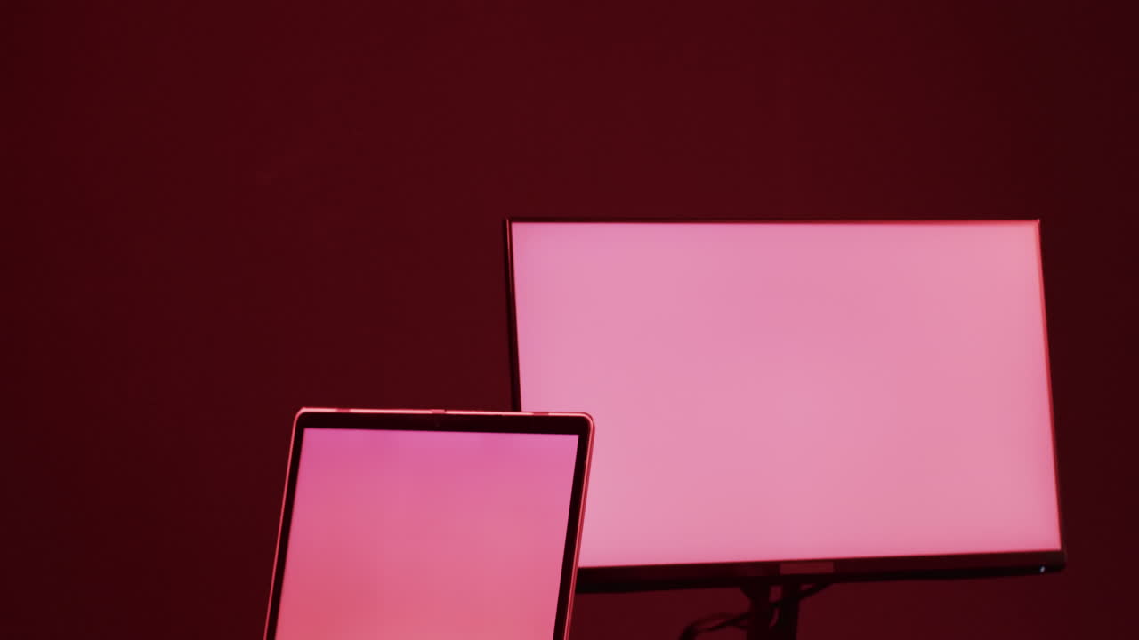 video de computadora y portátil con pantallas en blanco, espacio de copia en fondo de neón