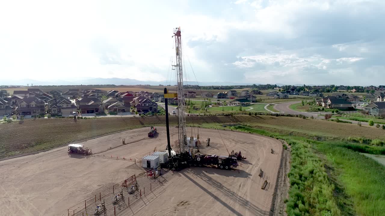 una foto de un dron de un pozo de petróleo extraordinariamente cerca de un barrio lujoso y rico