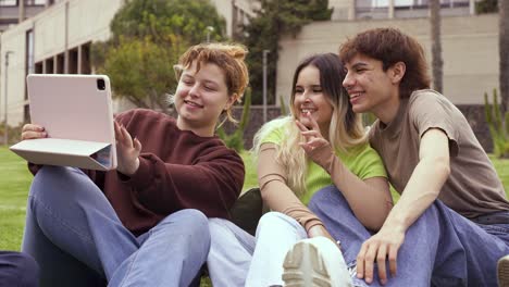 cheerful friends using tablet at university campus