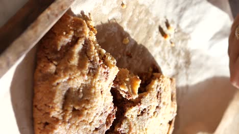 a broken chocolate chip cookie on a wooden tray