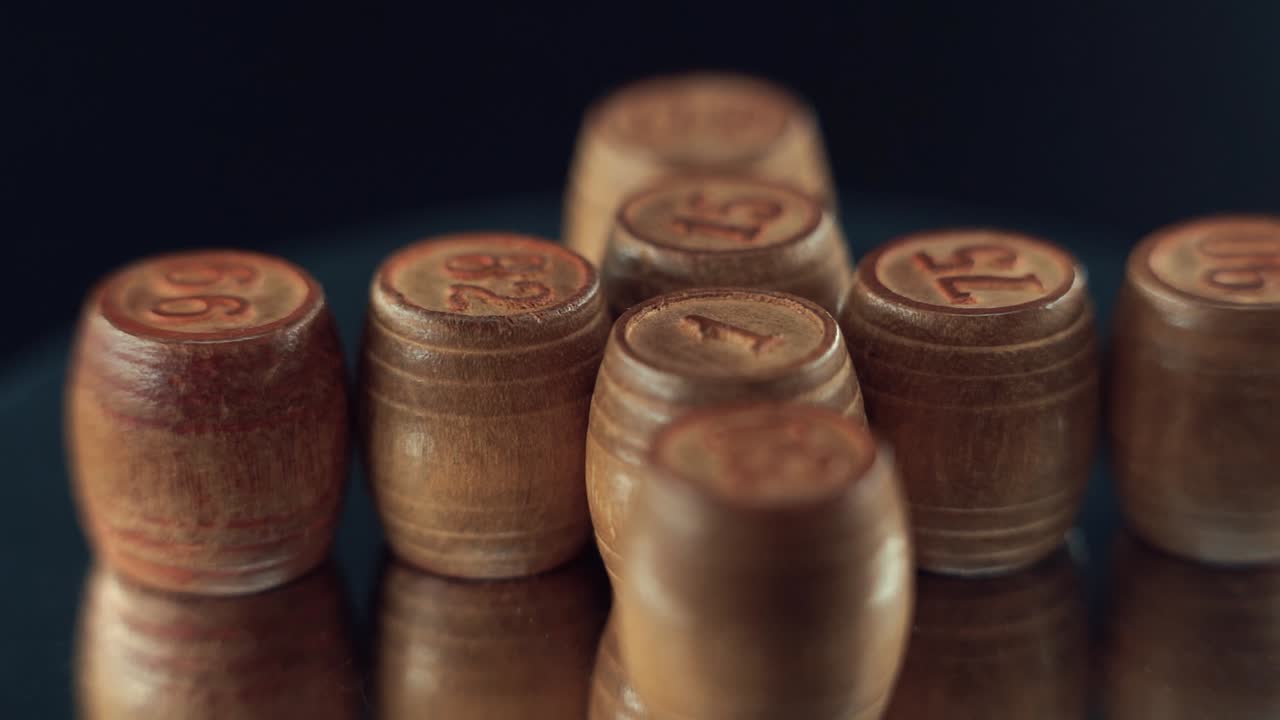 Macro video of wooden Bingo barrels, casino gambling game, digits on top, 360 rotating numbers, 120 fps, slow motion, mirror reflection