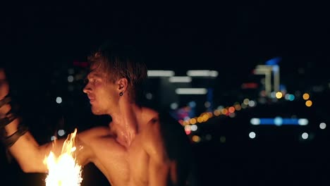 Young-blond-male-spins-two-burning-pois-Slow-motion-Closeup