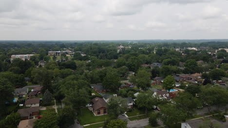 Aerial-dolly-above-tree-covered-suburban-neighborhood-on-cloudy-overcast-day