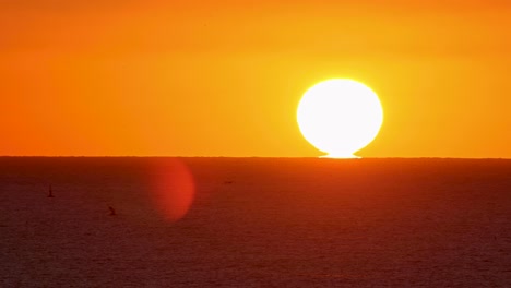 Weite-Nahaufnahme-Der-Sonne,-Die-über-Ein-Paar-Boote-Untergeht