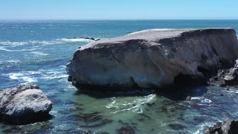 erosion along a rocky ocean shoreline creates rugged cliffs and beautiful vistas - sliding aerial view