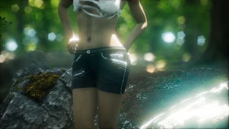 young woman in torn t-shirt in green forest