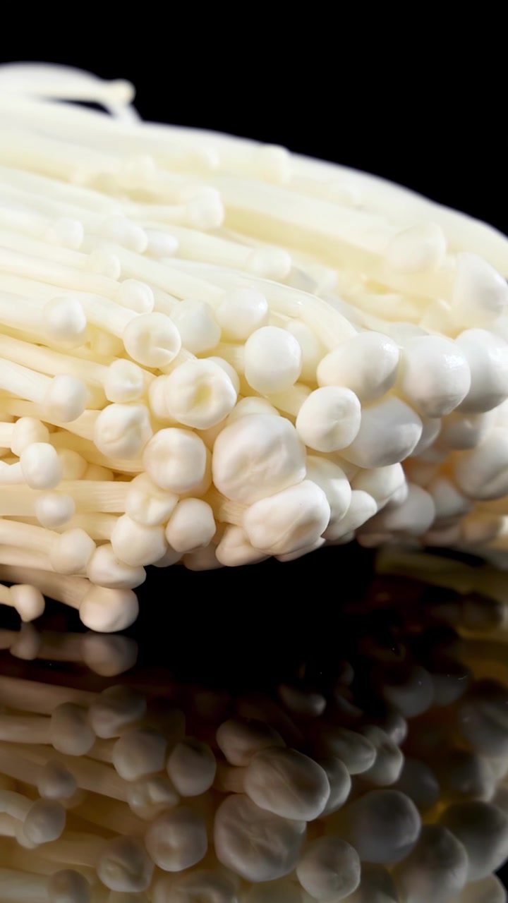 Primer plano de champiñones Enoki blancos frescos con reflejo.