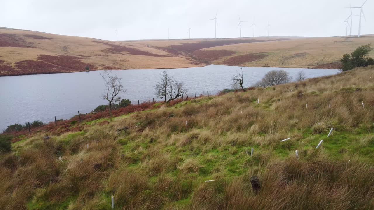 tiro de carro lateral aéreo bajo con turbinas eólicas y embalse uk 4k