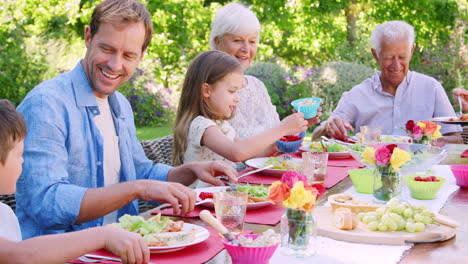 Familie-Mit-Drei-Generationen-Beim-Mittagessen-Im-Garten