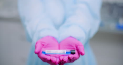 investigador sosteniendo el tubo de muestra covid 19 en la mano 6