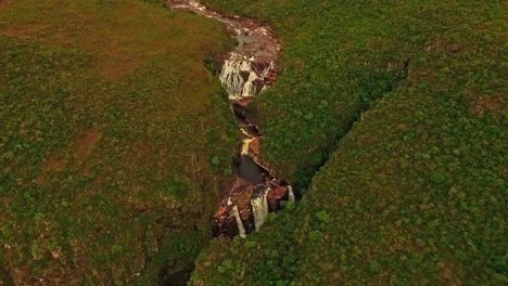 antena inclinándose sobre un río que desemboca en una cascada en el campo sudamericano