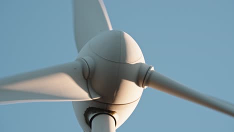 dynamic low angle view of a wind turbine against a clear sky, highlighting renewable energy infrastructure