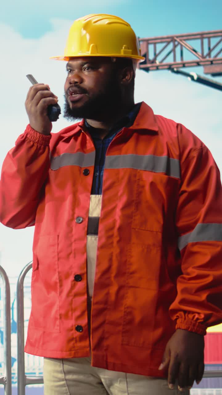Vertical video Offshore platform worker speaking in walkie talkie, scheduling equipment repairs