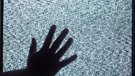 hand over a static television screen