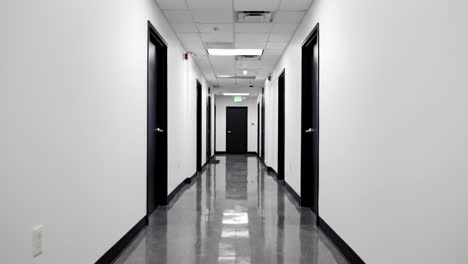 a modern, sleek hallway featuring glossy floors and black doors, highlighting an inviting yet professional space within a contemporary building
