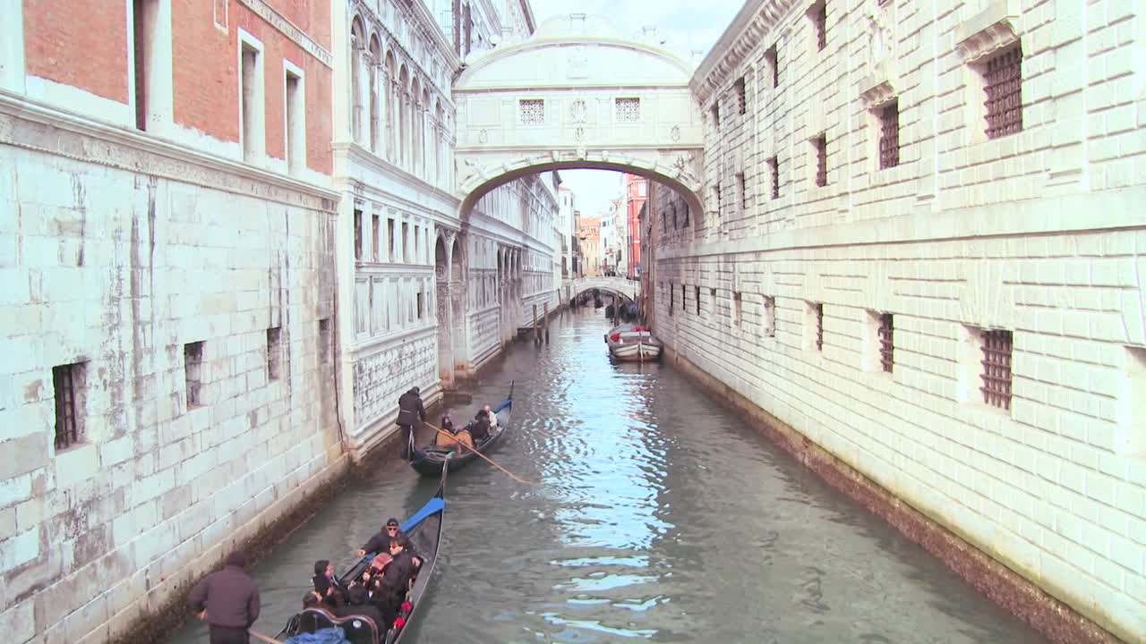 곤돌라가 이탈리아 베니스에서 탄식의 다리 아래를 통과합니다.