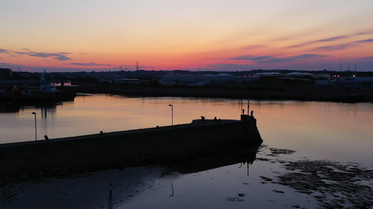 일출의 푸른 시간 빛은 nimmos pier galway ireland의 멋진 주황색 하늘을 반영합니다.