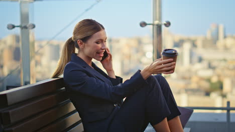 relaxed businesswoman calling smartphone on glass terrace. smiling manager rest